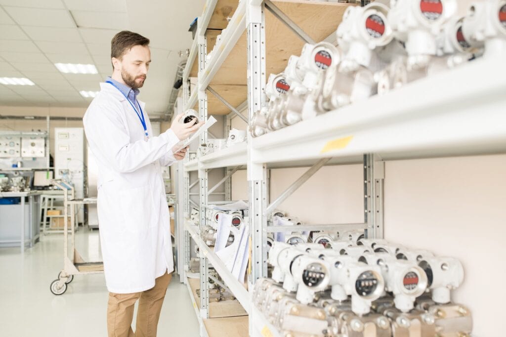 Busy quality control engineer examining manometers in warehouse